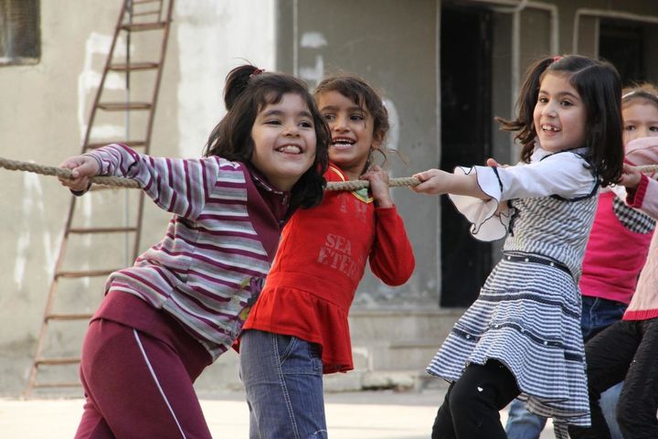 Displaced children participating in UNICEF-supported psychosocial activities play tug of war, in a shelter in the city of Homs, capital of Homs Governorate.