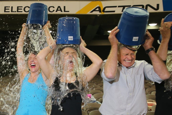 MELBOURNE, AUSTRALIA - AUGUST 22: Participants tip buckets of ice water over their heads as they take part in the World Record Ice Bucket Challenge at Etihad Stadium on August 22, 2014 in Melbourne, Australia. Over 700 people took part in setting the new world record. The Ice Bucket Challenge is the social media phenomenon which is helping raise awareness and money for sufferers of Motor Neurone Disease. (Photo by Scott Barbour/Getty Images)