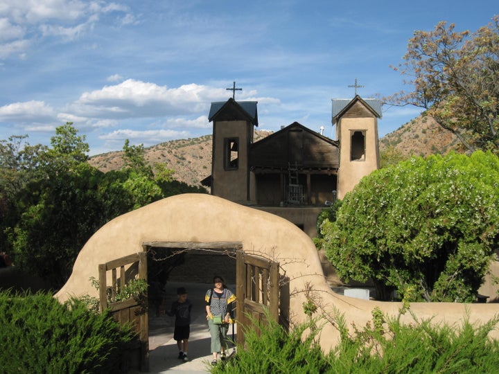 This October 2012 photo shows the Santuario de Chimayo, a picture-perfect adobe church with wooden gates. This 200-year-old National Historic Landmark attracts 200,000 visitors a year, many of whom seek cures and miracles from a well of holy dirt called el pocito. (AP Photo/Beth Harpaz)