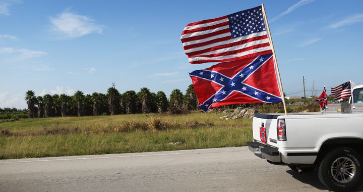 LOXAHATCHEE, FL - JULY 11: An American and Confederate flag fly from a vehicle during a rally to show support for the flags on July 11, 2015 in Loxahatchee, Florida. Organizers of the rally said that after the Confederate flag was removed from South Carolinas State House it reinforced their need to show support for the Confederate flag which some feel is under attack. (Photo by Joe Raedle/Getty Images)