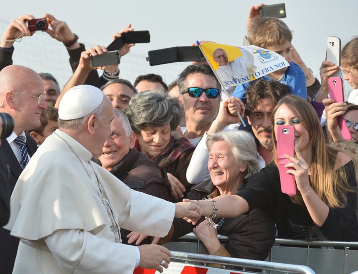 People take pictures with their mobile phones as Pope Francis arrives to visit the Roman parish of "Santa Maria dell'Orazione" in Guidonia Montecelio near Rome on March 16, 2014. AFP PHOTO / ALBERTO PIZZOLI (Photo credit should read ALBERTO PIZZOLI/AFP/Getty Images)