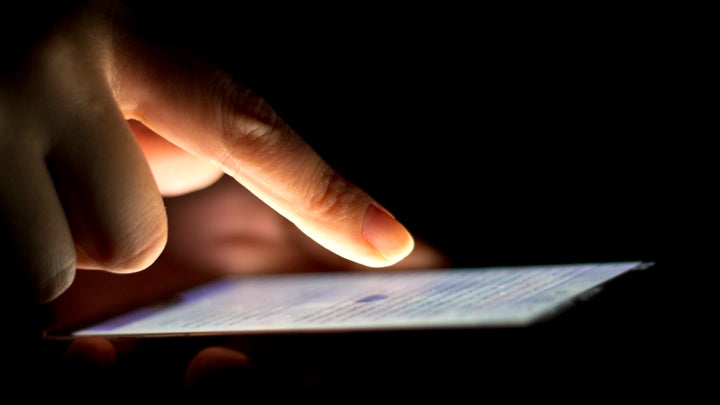 Close-up of a hand hovering above a smartphone in a dark room. The only source of illumination is the cellphone.If you use this image, please attribute it with a link reading "Japanexperterna" to www.japanexperterna.se, or, where this is not possible, non-linked text reading "Japanexperterna.se" The URI (URL) that should be associated with this Work is: www.japanexperterna.se/?attachment_id=3069åçã®è»¢è¼ã«ã¤ãã¦ï¼åçã®è»¢è¼ã»ä½¿ç¨ã¯æè¿ãããã¾ããããã®éã«å¿ãwww.japanexperterna.seã¸ãªã³ã¯ããã ããããé¡ããã¾ããï¼å°å·ã¯é¤ãï¼