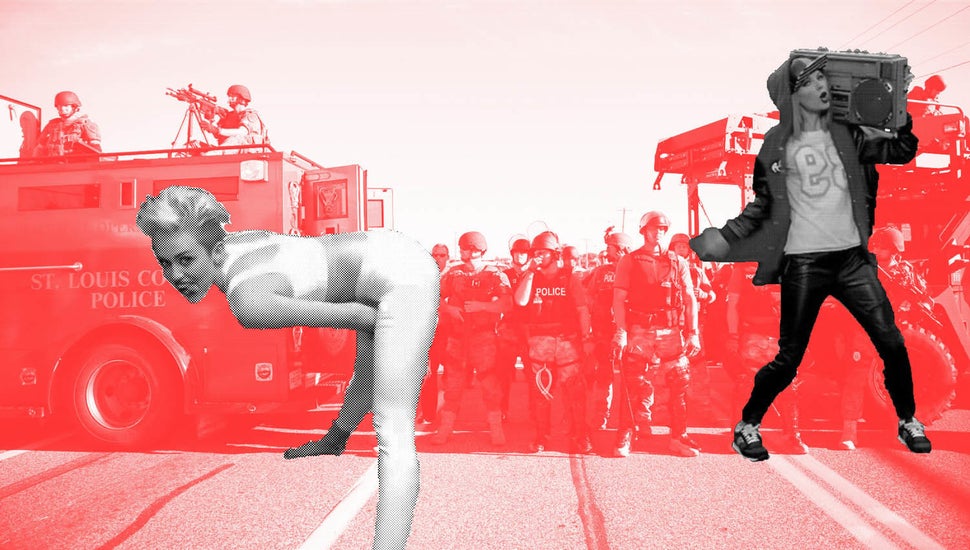Police in riot gear watch protesters in Ferguson, Mo. on Wednesday, Aug. 13, 2014. On Saturday, Aug. 9, 2014, a white police