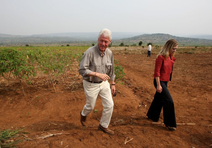 RWINKWAVU, RWANDA - AUGUST 02: Former U.S. President Bill Clinton (L) and his daughter Chelsea visit a cassava farm August 2