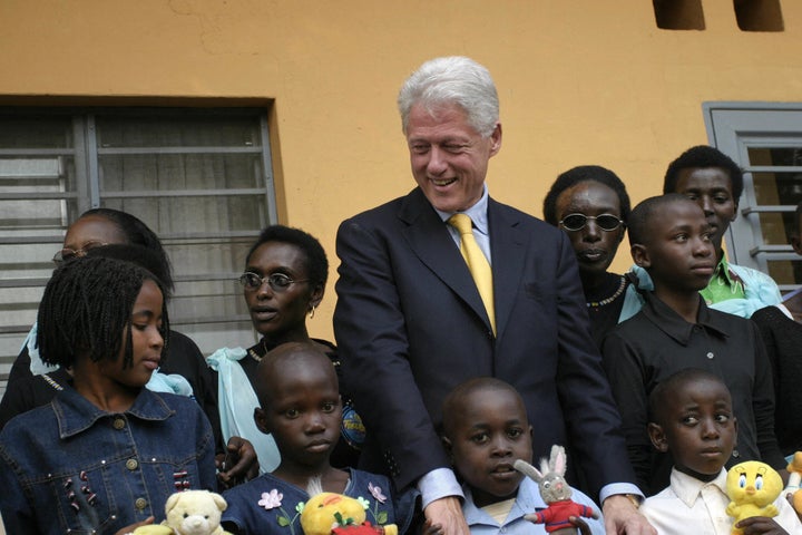 Kigali, RWANDA: Former US President, Bill Clinton, poses 23 July 2005 with HIV positive children at the Treatment and Reseach Aids Center in Kigali, Rwanda. The HIV infection rate in the Rwandan countryside is a little over four percent, in the towns 11 percent. AFP PHOTO/JOSE CENDON (Photo credit should read JOSE CENDON/AFP/Getty Images)