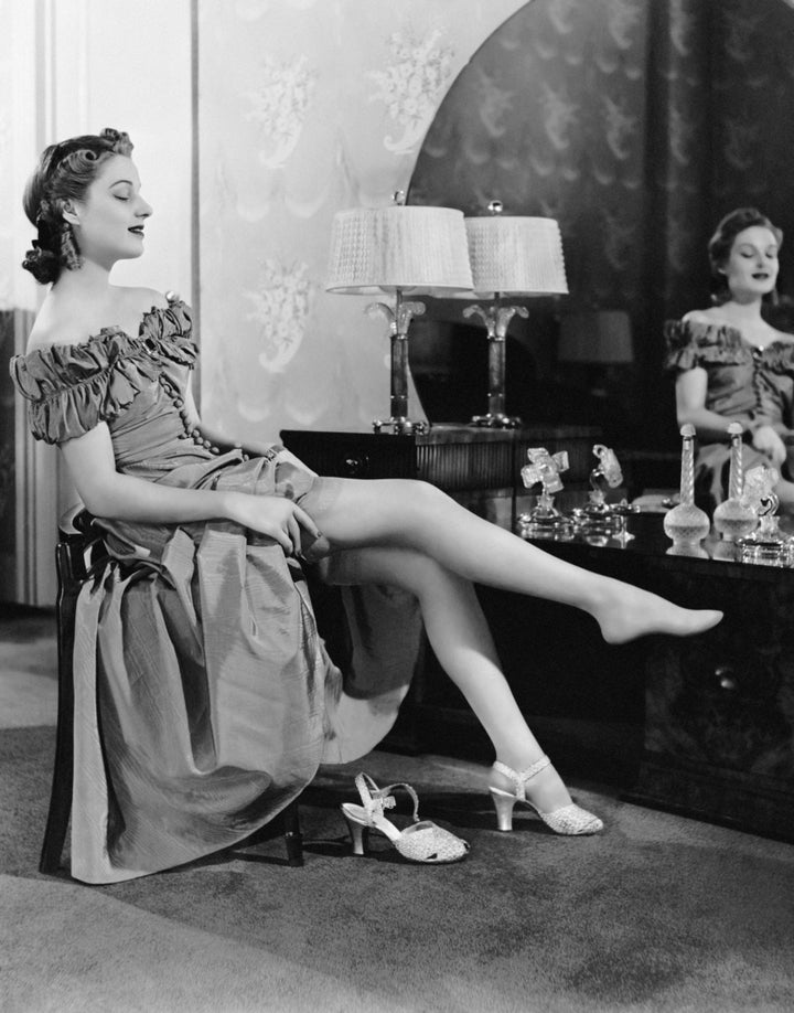 UNITED STATES - CIRCA 1950s: Woman at dressing table putting on stockings. (Photo by George Marks/Retrofile/Getty Images)