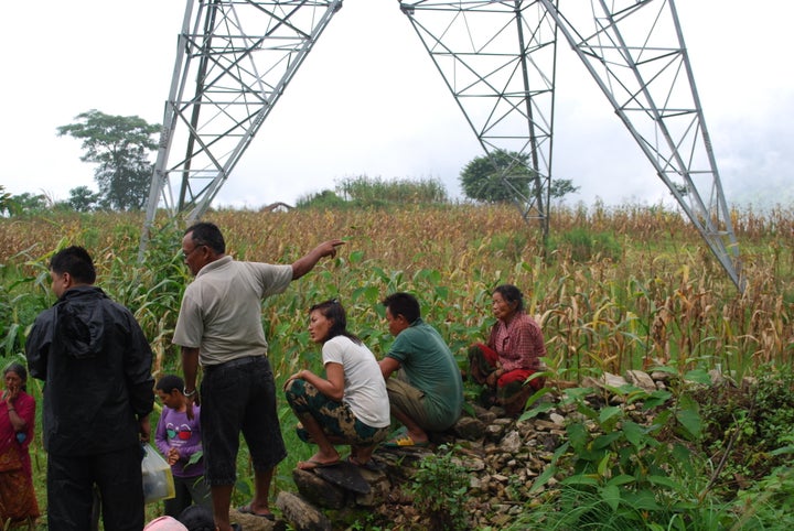 Nepalese villagers, in the shadow of a controversial high-voltage transmission line financed by the World Bank
