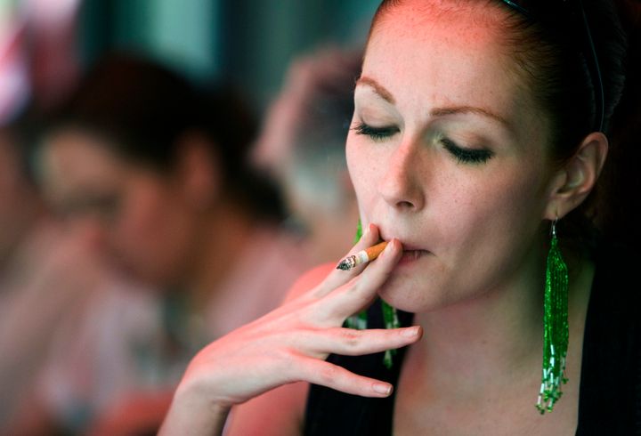 A woman smokes in a restaurant in Mexico City, Wednesday, April 2, 2008. A law banning smoking in virtually all public spaces in Mexico City , exceptions include parks, soccer stadiums and outdoor seating areas, goes into effect Thursday. (AP Photo/Alexandre Meneghini)