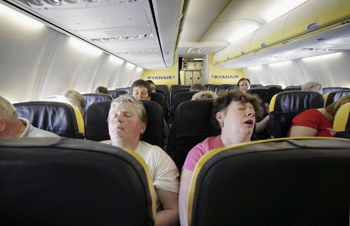 <p>Passengers sleep on a flight from London to Dinard, France.</p>