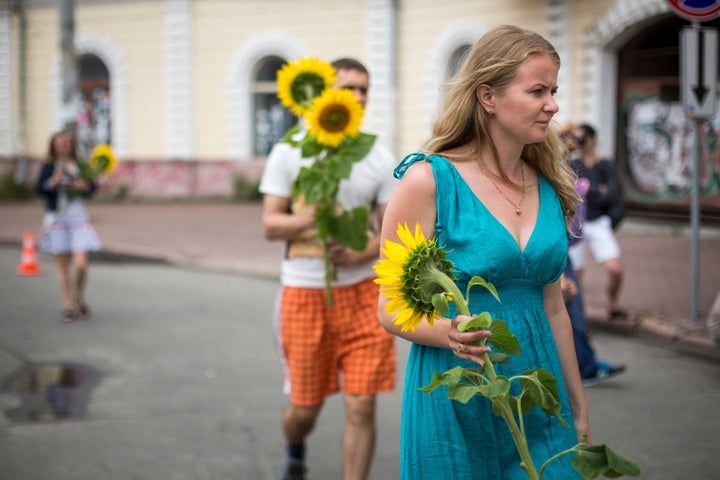 KIEV, UKRAINE - JULY 19: People bring sunflowers to place in front of the Netherlands Embassy in memory of the victims of Malaysia Airlines flight MH17 on July 19, 2014 in Kiev, Ukraine. Malaysia Airlines flight MH17 was travelling from Amsterdam to Kuala Lumpur when it crashed killing all 298 on board including 80 children. The aircraft was allegedly shot down by a missile and investigations continue over the perpetrators of the attack. (Photo by Rob Stothard/Getty Images)