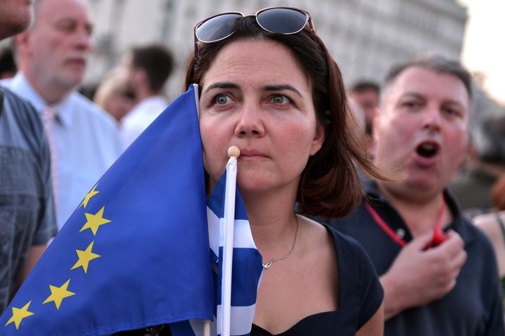 A Greek woman in Athens holding both the European Union flag and the Greek flag.