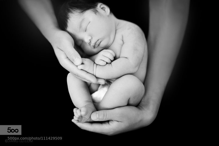 Baby boy sleep deeply in the hands of daddy.