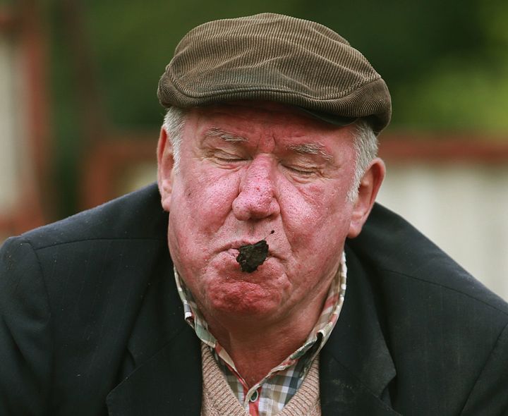 <p>Adrian Jones takes his turn in the dung-spitting contest on July 17, 2015.</p>