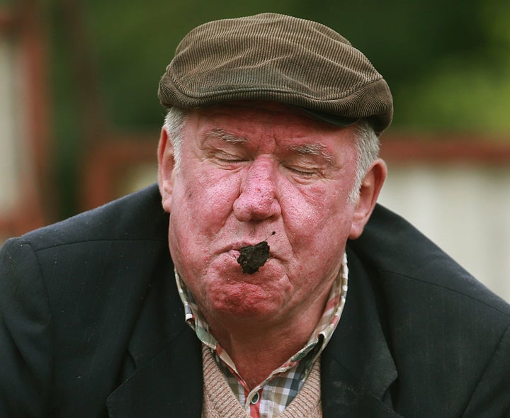 Adrian Jones takes his turn in the dung-spitting contest on July 17, 2015.