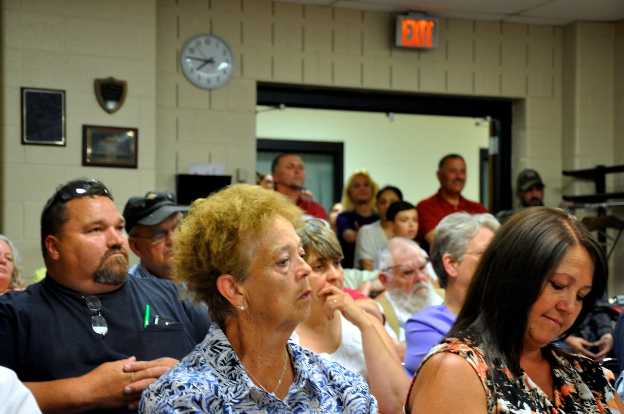 The Salhas stand in the back of the crowded June planning commission meeting. Most public comment was opposed to the camp. Previously, the board of Rose Township, which borders David Salha's property, voted 5-0 to request that the county deny his permit. The property is in Goodar Township; their board voted 3-1 on a resolution to offer no objection.