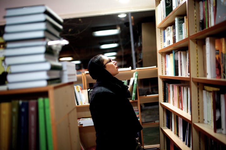 A woman looks at the books at a book store in Tehran on December 30, 2013