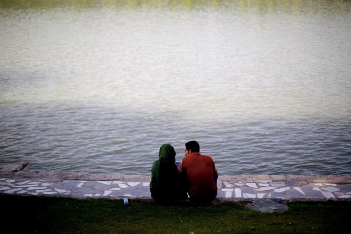 An Iranian couple sit on the bank of Zayandeh-roud river in the historic city of Isfahan, Iran on April 21, 2015. 