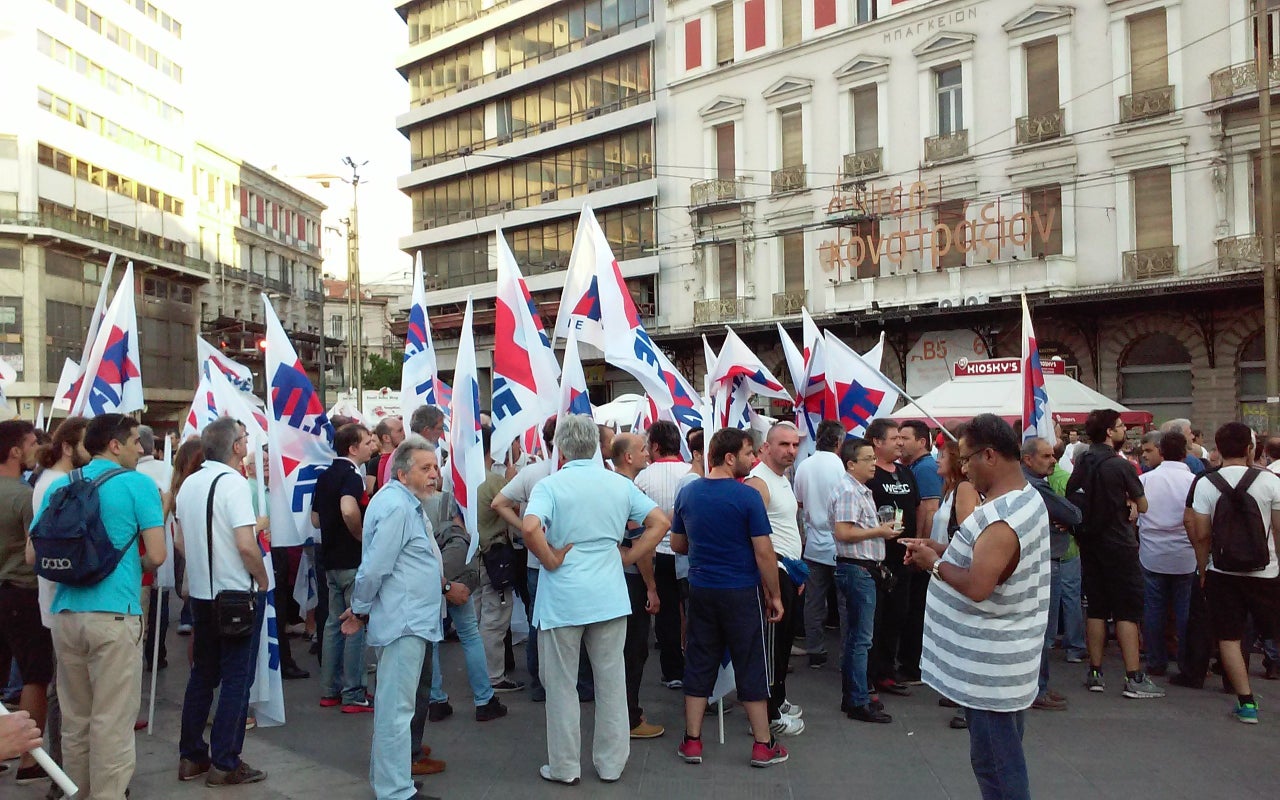 Anti-austerity demonstrators hold flags as they gather near Syntagma Square on July 22, 2015.