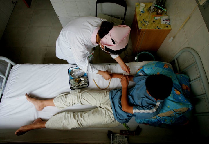 A nurse inserts an intravenous drip into a 12-year-old boy's arm at the Beijing Military Region Central Hospital in Beijing o