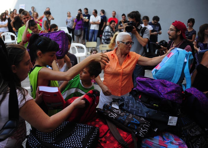 <p>Spanish activists distribute free school supplies to families squatting in a building in Sevilla, Spain, in 2013.</p>