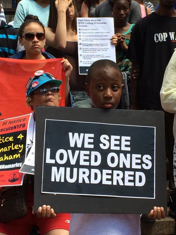 Ramarley Graham's 9-year-old brother, Chinnor Campbell, holds a sign at a rally on Thursday, July 23, 2015.