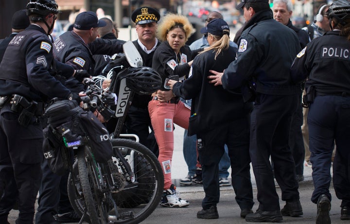 Police arrest a demonstrator during a protest held to draw attention to the shooting of unarmed men by police on April 14, 2015 in Chicago, Illinois.