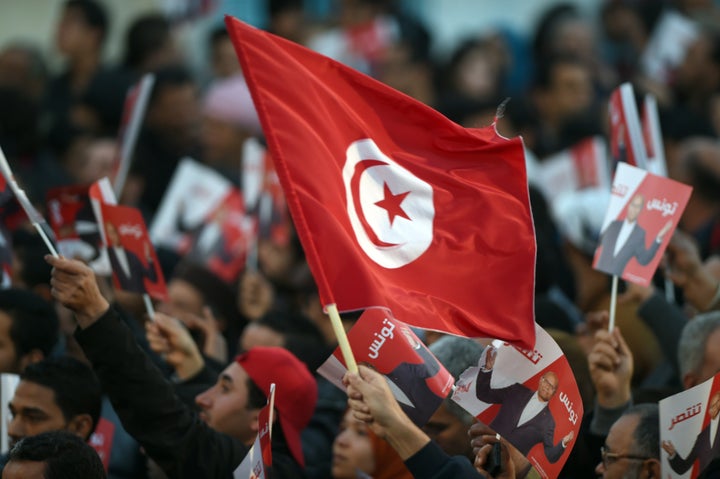 A Marzouki supporter holds a Tunisian flag during a rally.