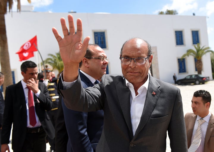 Former Tunisian President Moncef Marzouki arrives to take part in an anti-extremism march, in Tunis, on March 29, 2015, follo