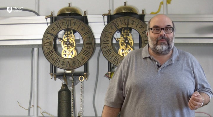 <span>Dr. Luis Melo with the pendulum clocks used to confirm the mathematical model of the pendulums' synchronization. <