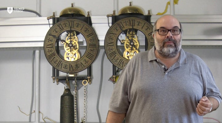 Dr. Luis Melo with the pendulum clocks used to confirm the mathematical model of the pendulums' synchronization. 