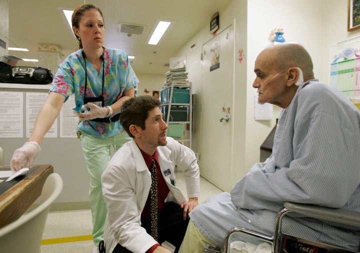 Dr. Joseph Bick, center, talks to Hepatitis C patient Richard Carreiro, as nurse Laura Escareno-Scarrott, watches in the hospice of the California Medical Facility in Vacaville, Calif., Jan. 17, 2007. Bick, as chief medical office at the prison facility, sees many inmates with the deadly disease. (AP Photo/Marcio Jose Sanchez)