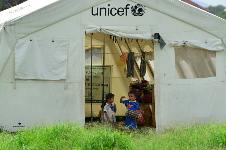 In this photograph taken on July 23, 2015, Nepalese children play with a drum at a relief camp for earthquake survivors in Kathmandu.