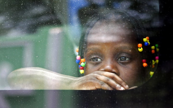 A Haitian girl looks from the window of a vehicle as her family is transported to be voluntarily repatriated in Santo Domingo on June 29, 2015. Some Haitians have chosen for volunteer repatriation before the start of the deportations of those who do not comply with the Dominican National Reorganization Plan for Foreigners. (ERIKA SANTELICES/AFP/Getty Images)