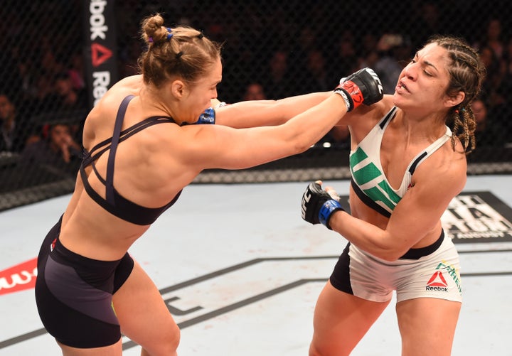 Ronda Rousey of the United States punches Bethe Correia of Brazil in their UFC women's bantamweight championship bout during the UFC 190 event inside HSBC Arena on August 1, 2015 in Rio de Janeiro, Brazil.