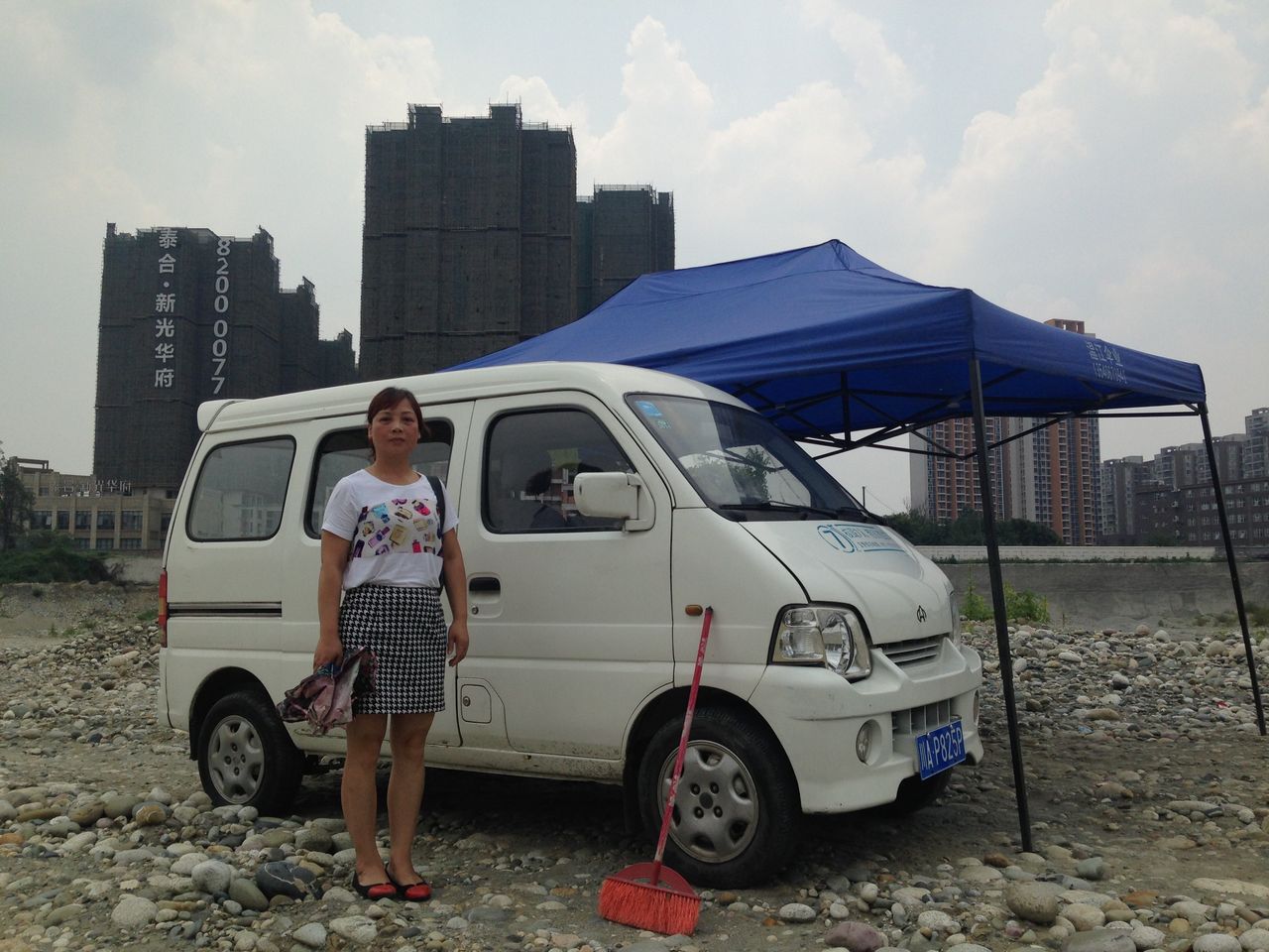 <p>Yuan Ying stands beside the car that she uses to block construction on the site of her former home.</p>