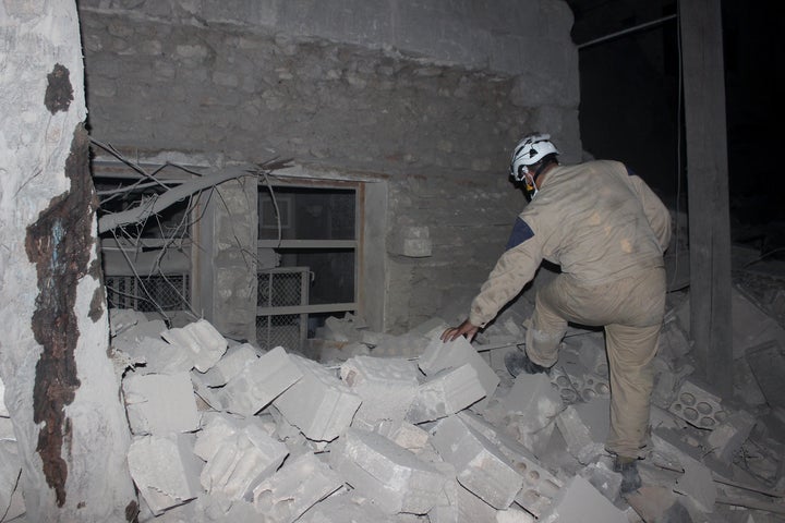 A search and rescue team member inspects the rubble after Assad forces barrel bomb attack to Aleppo, Syria, on August 2, 2015.