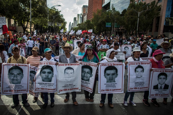 Demonstrators and relatives of the 43 missing students of Ayotzinapa college march during a protest rally ten months after the students disappearance on July 26, 2015 in Mexico City.