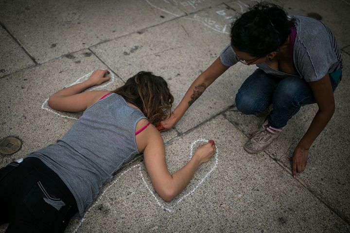 A woman paints the silhouette of a girl during a protest to demand the safe return of the 43 missing students of Ayotzinapa, on June 26, 2015 in Mexico City.