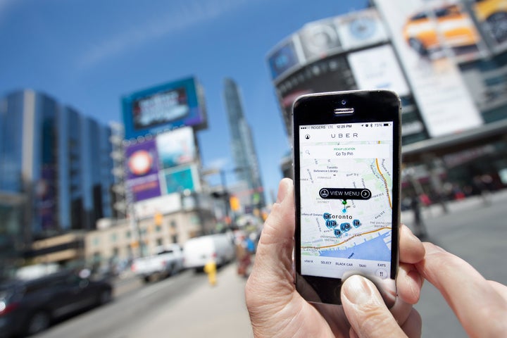 TORONTO, ON - MAY 14 - Photographed at Dundas Square, Toronto, Uber taxi service is a new alternative way to traditional taxi to travel around the city.