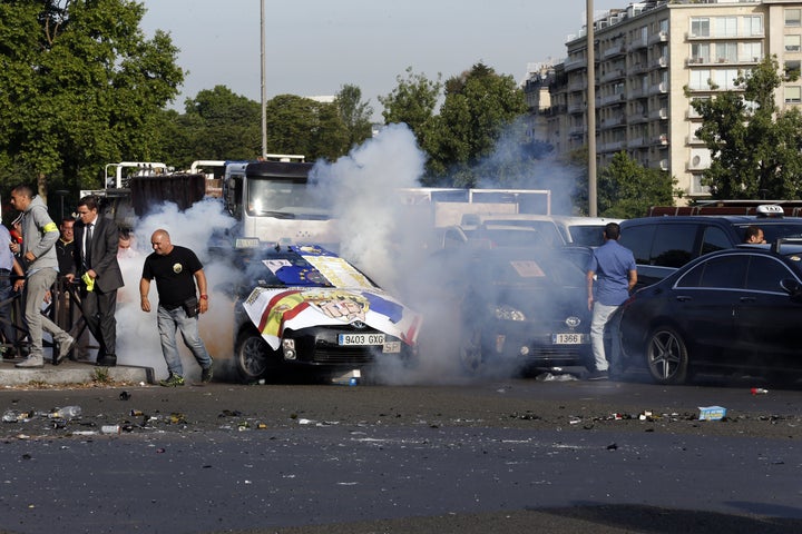 Smoke rises as demonstrators light firecrackers at Porte Maillot in Paris on June 25, 2015, as hundreds of taxi drivers converged on airports and other areas around the capital to demonstrate against UberPOP.