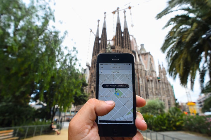  BARCELONA, SPAIN - JULY 01: In this photo illustration the new smart phone taxi app 'Uber' shows how to select a pick up location backdropped by La Sagrada Familia on July 1, 2014 in Barcelona, Spain.