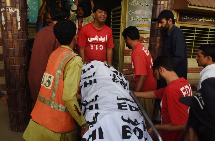 Pakistani volunteers shift Shafqat Hussain's body to a mortuary after his execution in Karachi on Aug. 4, 2015.