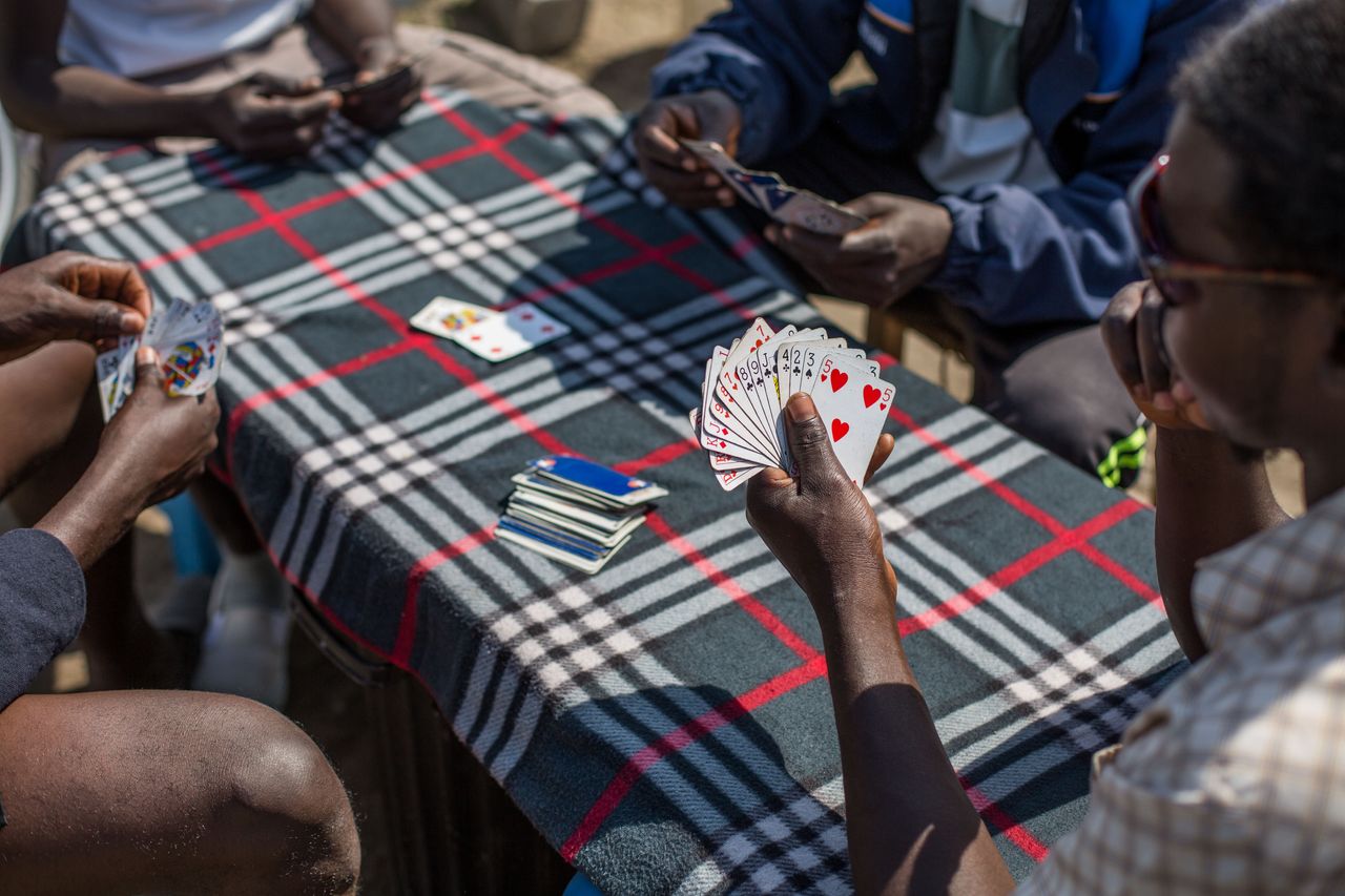 Sudanese men play cards in a makeshift camp near the port of Calais, Aug. 1, 2015. 
