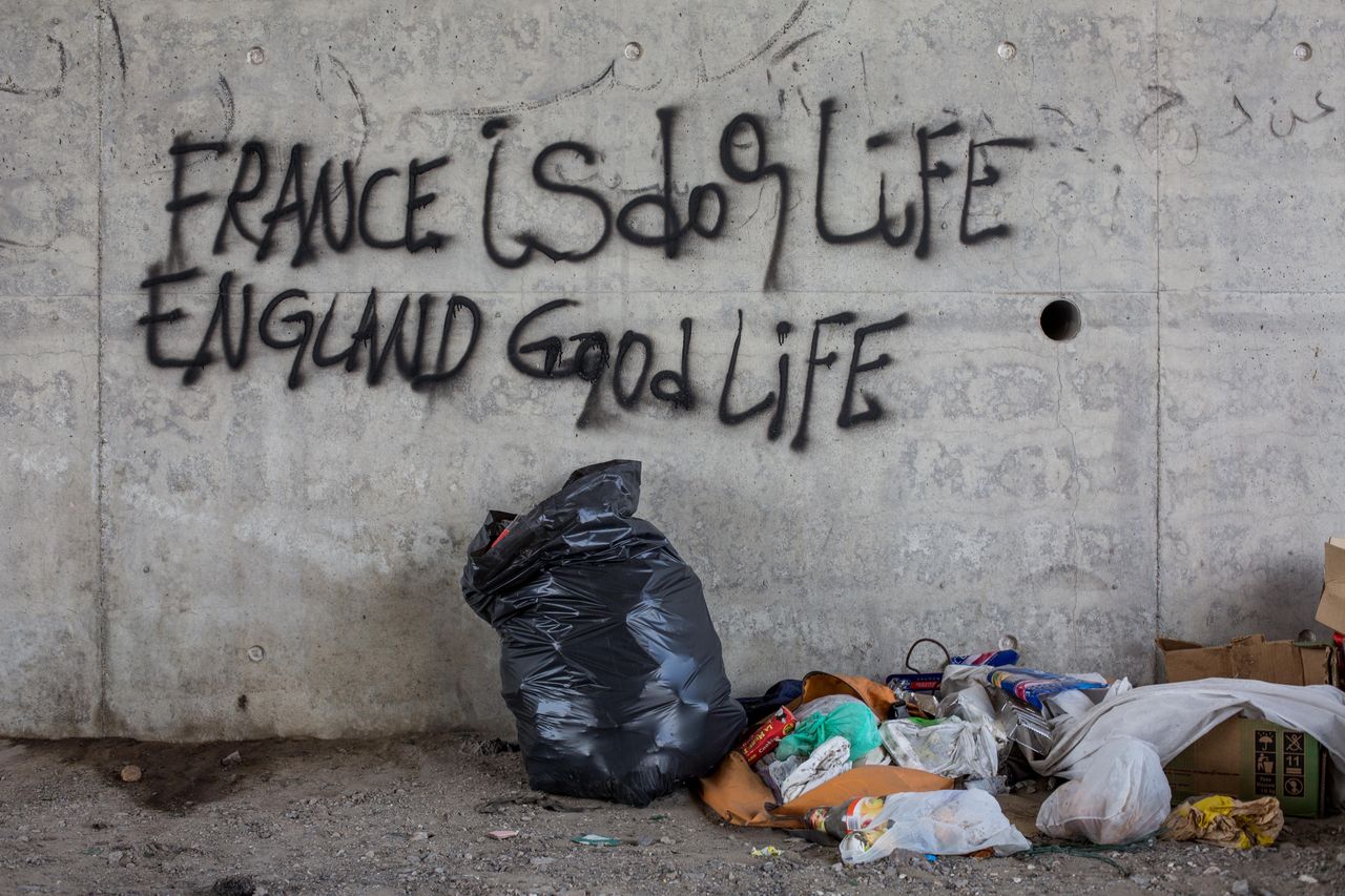 Graffiti reading 'France is dog life, England good life' is seen on a wall close to a makeshift camp near the port of Calais on Aug. 1, 2015. 