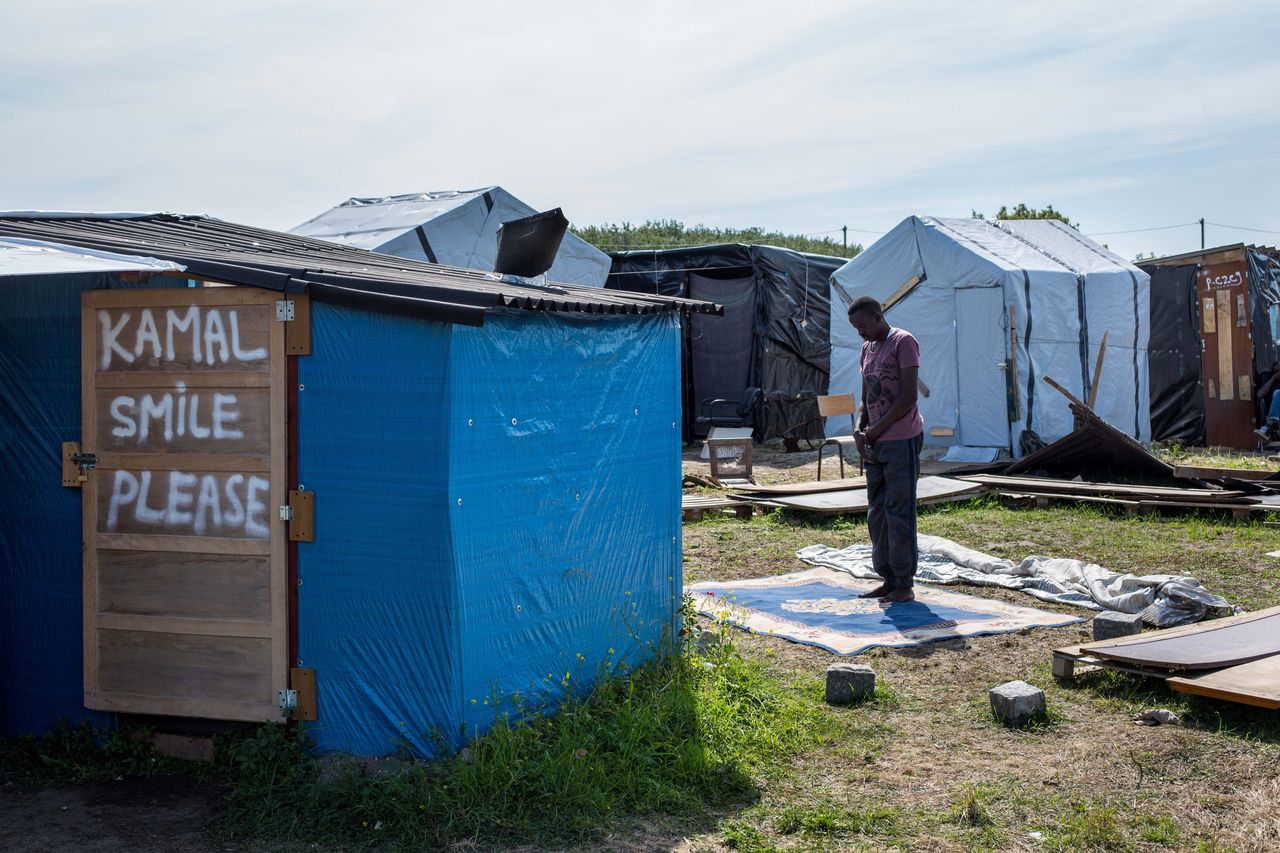 A man prays in a makeshift camp near the port of Calais on Aug. 1, 2015. 