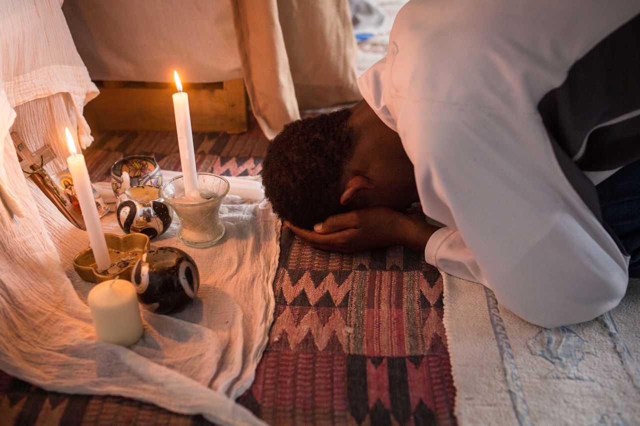 A man prays during an Orthodox service for Ethiopian and Eritrean worshippers at a church in a makeshift camp near the port of Calais on Aug. 2, 2015.