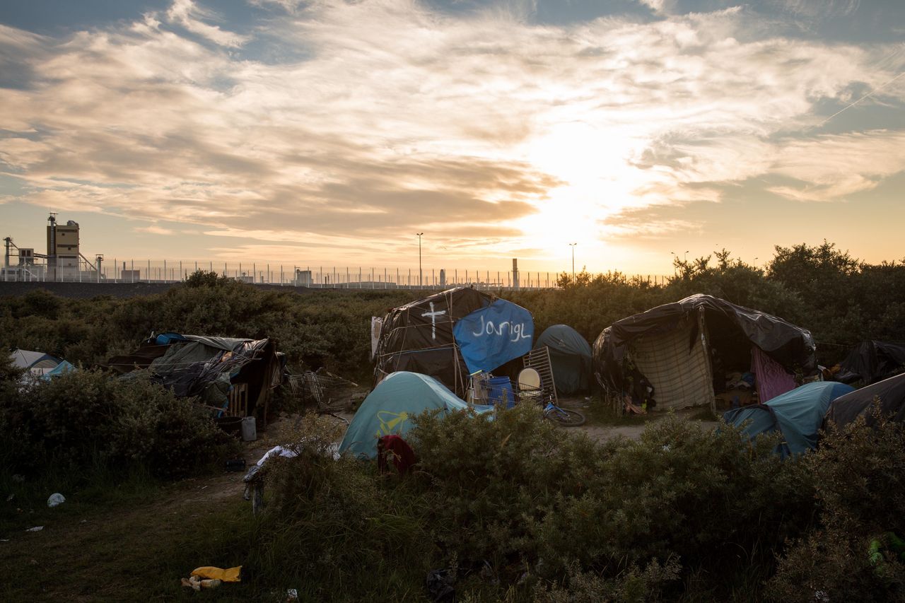 The sun sets behind a makeshift camp near the port of Calais on Aug. 2, 2015. 