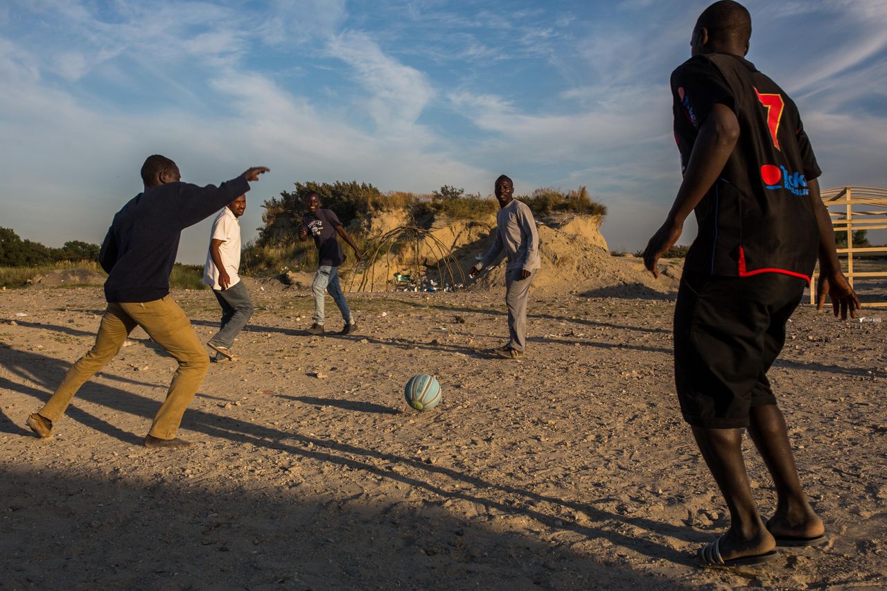 Men play football in a makeshift camp near the port of Calais on Aug. 2, 2015. 