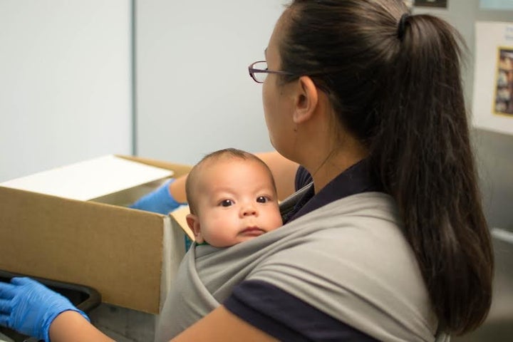 <p>The Milk Bank's pasteurization coordinator at work with her baby.</p>