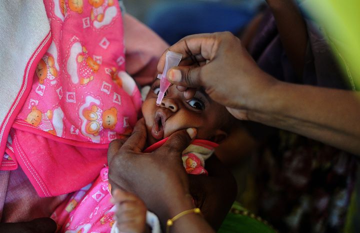 <p>A Somali baby is given a polio vaccination before being given a pentavalent vaccine injection at a medical clinic in Mogadishu on April 24, 2013. </p>